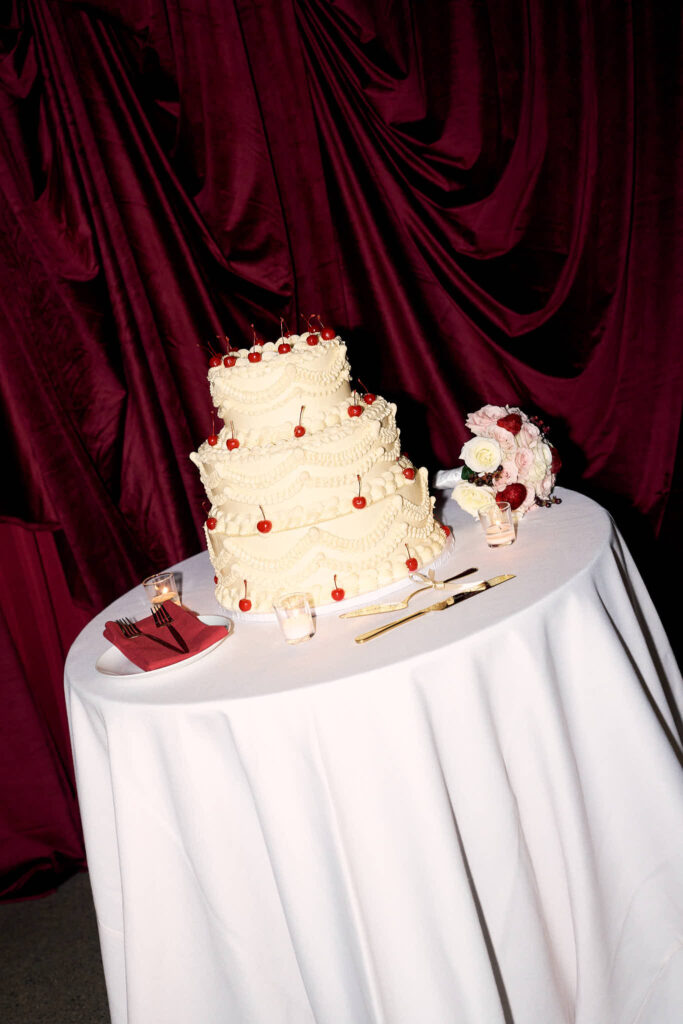 Modern wedding cake with cherries and editorial backdrop