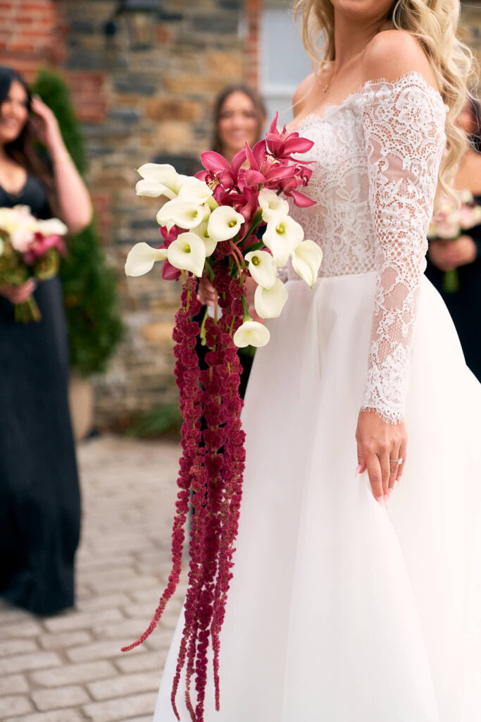 Bride holds a cascading bouquet with her bridal party