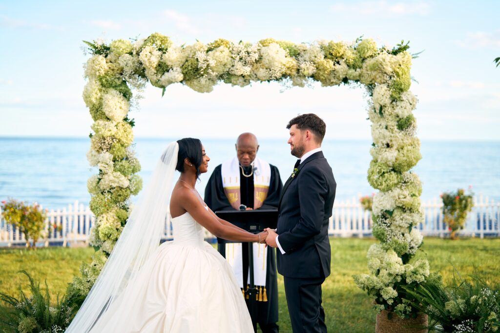 Bride and groom hold hands at their Water's Edge wedding ceremony in Westbrook