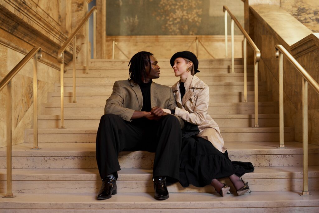 Engaged couple sitting on the grand staircase at the Boston Public Library