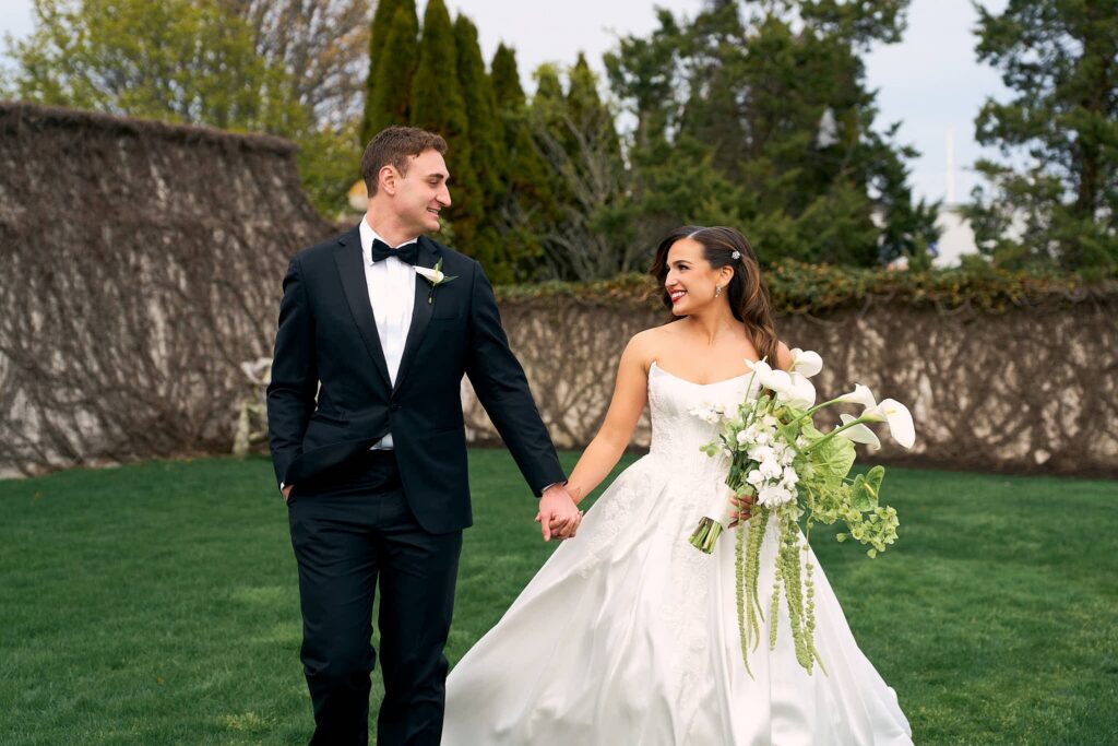 Bride and groom hold hands at Belle Mer wedding