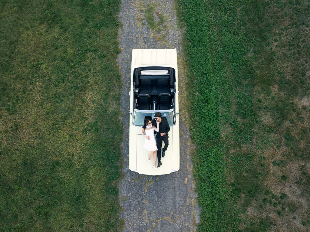 Couple lay on a vintage car for Aldrich Mansion engagement session