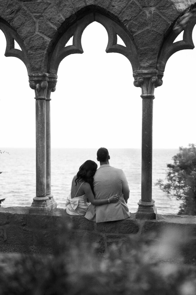 Couple look out at the water at Hammond Castle in New England engagement photo